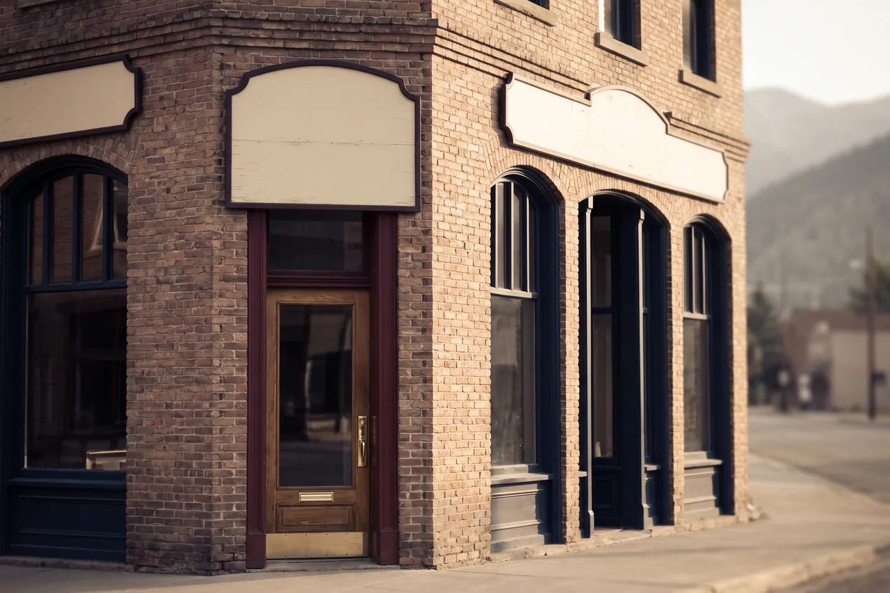 The corner entrance of the Aldous Block, a 1911 two-storey brick building, in raking morning light